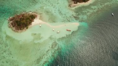 Beyaz kumlu sahili olan küçük torpik bir ada..