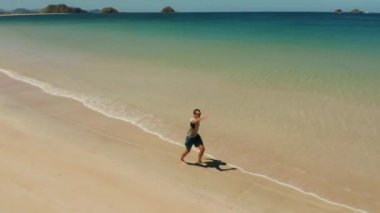 Yazın sahilde koşan bir adam.