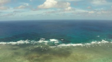 Deniz manzarası, mavi deniz, bulutlu ve adalı gökyüzü.