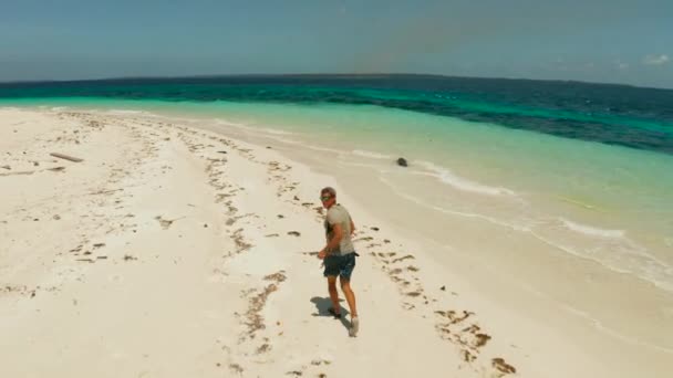 Man loopt op een zandstrand op vakantie. — Stockvideo