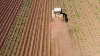 Patates tarlasında tarım makineleri toprağı işliyor.