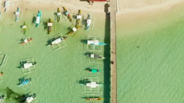 Denizde tekneleri olan bir iskele, hava manzaralı. General Luna, Siargao adası..