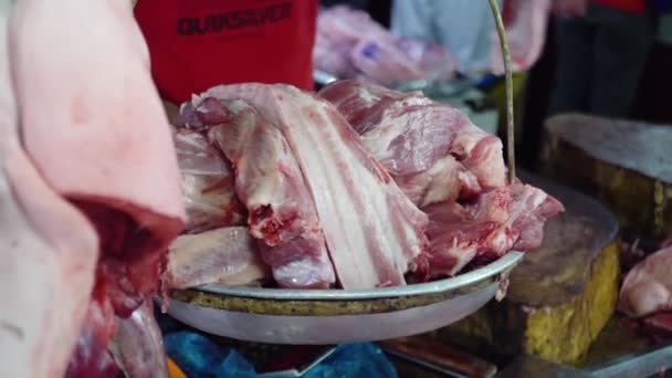 Vendeur pèse la viande sur les balances sur le marché. — Video