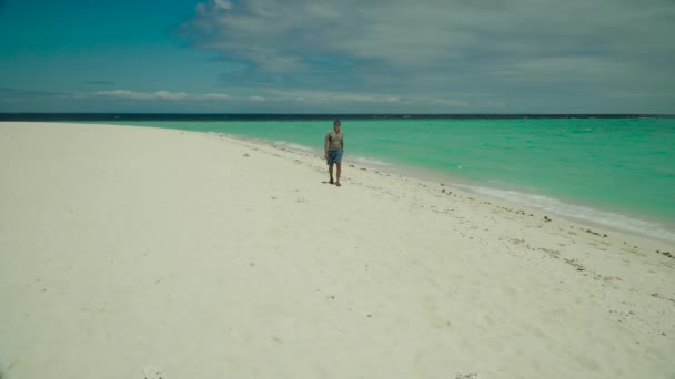 A man walks along a sandy beach — Stock Video