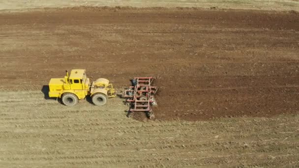 Mezőgazdasági területen tárcsás boronával felszerelt traktor — Stock videók