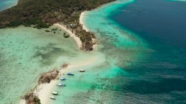 Beyaz kumlu sahili olan küçük torpik bir ada..