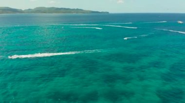 Tropik bir tatil beldesinde jet ski süren turistler. Boracay, Filipinler