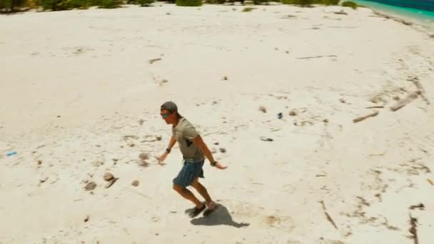 Homem corre em uma praia de areia em férias . — Vídeo de Stock