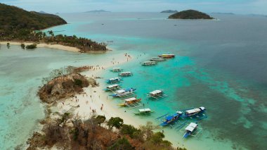 Beyaz kumlu sahili olan küçük torpik bir ada..