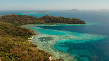 Beyaz kumlu sahili olan küçük torpik bir ada..