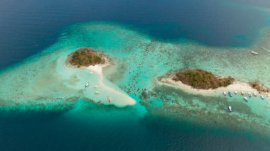 Beyaz kumlu sahili olan küçük torpik bir ada..