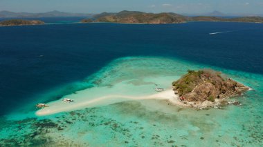Beyaz kumlu sahili olan küçük torpik bir ada..
