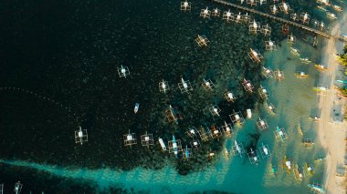 Denizde tekneleri olan bir iskele, hava manzaralı. General Luna, Siargao adası..