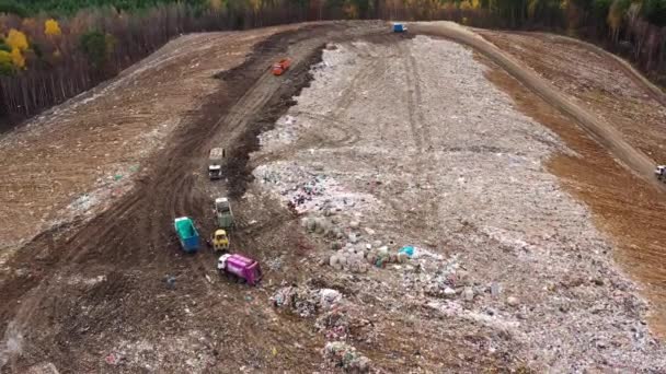 Des bulldozers et des camions à ordures dans une décharge. Montagne de déchets ménagers, vue d'en haut . — Video