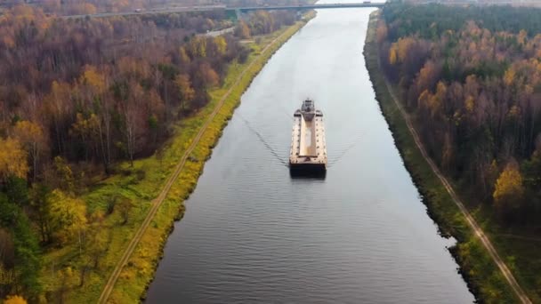 Uitzicht vanuit de lucht: Schip op de rivier. Herfstlandschap, rivierkanaal bij het bos. — Stockvideo