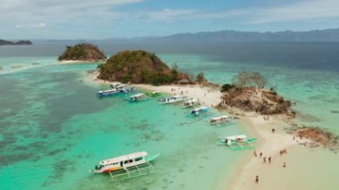 Beyaz kumlu sahili olan küçük torpik bir ada..