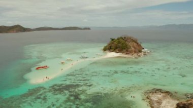 Beyaz kumlu sahili olan küçük torpik bir ada..