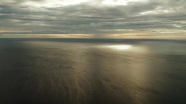 Gün batımında denizin üzerindeki bulutlu gökyüzü.