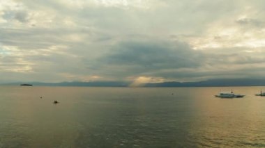 Gün batımında denizin üzerindeki bulutlu gökyüzü.