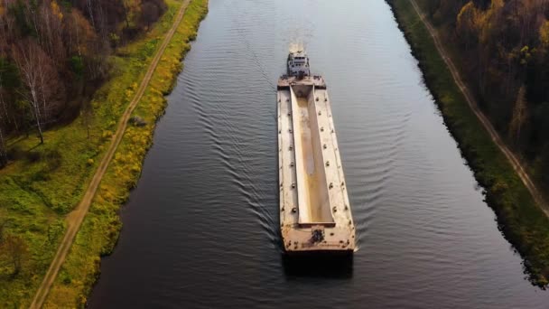 El remolcador del río mueve la barcaza de carga en el río. Paisaje otoñal. — Vídeo de stock