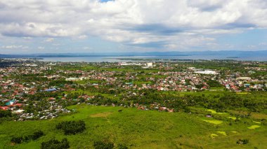 Tacloban, hava manzaralı. Kümülüs bulutlu şehir ve gökyüzü. Deniz kenarındaki Asya kasabası.