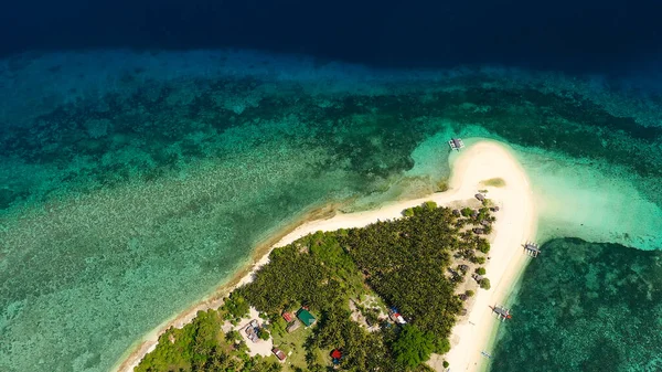 La isla de arena blanca en un gran atolón, vista desde arriba. Isla tropical con palmeras. Paisaje marino con una isla paradisíaca. —  Fotos de Stock