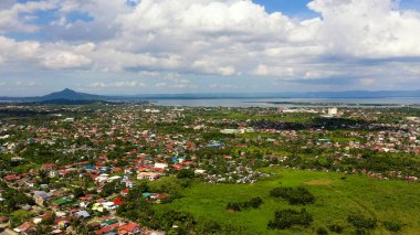 Tacloban, hava manzaralı. Kümülüs bulutlu şehir ve gökyüzü. Deniz kenarındaki Asya kasabası.