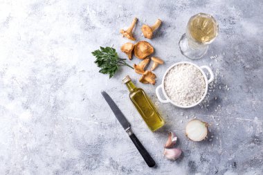 Mantarlı Risotto için malzemeler: Cantharellus cibarius mantar, arborio pirinç, sarımsak, şarap, soğan maydanoz ve zeytinyağı bir taş kartı. Üstten görünüm. Kopya alanı.