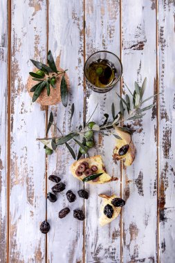 Geleneksel Yunan meze zeytin ekmek ve zeytinyağı ile beyaz ahşap zemin üzerinde rustik zeytin ahşap kurulunda görev yapmaktadır. Üstten görünüm
