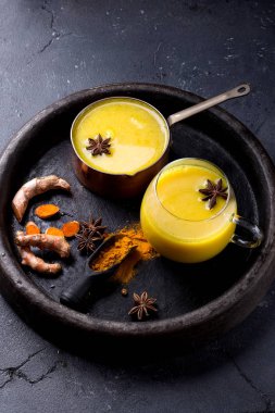 Tumeric süt chai siyah taş zemin tarçın, anason ve tumeric kökü ile görev yaptı. Kopya alanı