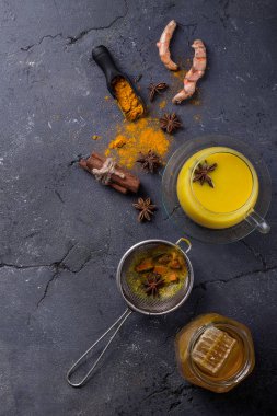 Tumeric süt chai tarçın, anason ve tumeric kökü, bal ve toz ile servis. Uzay kopyalayın. Üstten görünüm