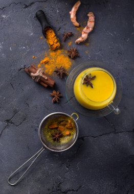 Tumeric süt chai tarçın, anason ve tumeric kökü, bal ve toz ile servis. Uzay kopyalayın. Üstten görünüm