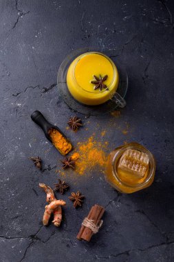 Tumeric süt chai tarçın, anason ve tumeric kökü, bal ve toz ile servis. Uzay kopyalayın. Üstten görünüm
