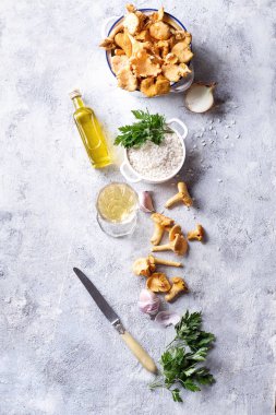 Mantarlı Risotto için malzemeler: Cantharellus cibarius mantar, arborio pirinç, sarımsak, şarap, soğan maydanoz ve zeytinyağı bir taş kartı. Üstten görünüm. Kopya alanı.