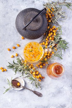 Ev bukthorn reçel ile taş bir tahta üzerinde hizmet topalak meyveleri ile çay yaptı. Üstten görünüm