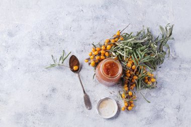 Ev bukthorn reçel ile taş bir tahta üzerinde hizmet topalak meyveleri ile çay yaptı. Üstten görünüm