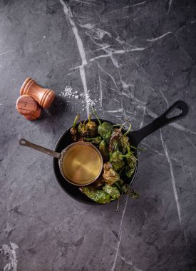 Geleneksel İspanyolca Tapas gizemli de Padron - kızarmış küçük biber deniz tuzu ve zeytinyağı ile hizmet vermektedir. Üstten görünüm. Kopya alanı