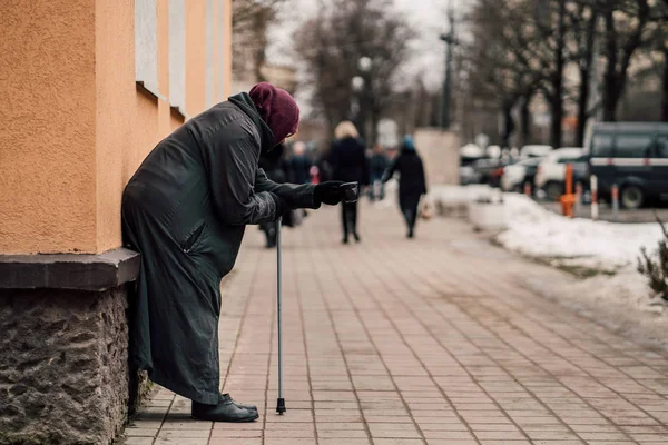 Photo of old hungry homeless female beggar beg for alms and on street. — Stock Photo, Image