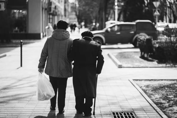 Rückansicht eines älteren Ehepaares, das auf der Straße spaziert. — Stockfoto