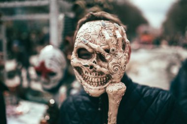 Karnaval veya Helloween zamanında sokakta kafatası maskesi adam. İskelet maskesi