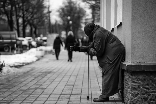 Foto van oude hongerig dakloze vrouwelijke bedelaar bedelen voor aalmoezen en op straat. — Stockfoto