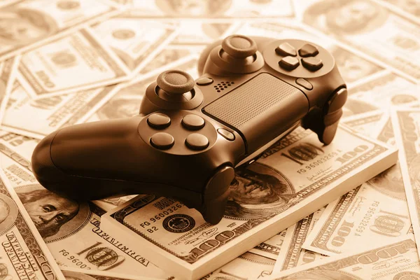 Concept of gaming addtion. Close up photo of gamepad on the money background.