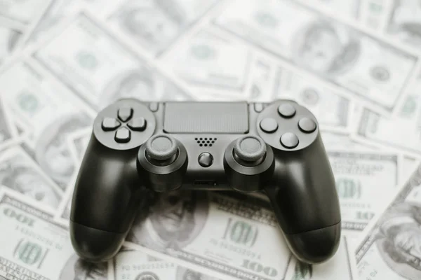 Concept of gaming addtion. Close up photo of gamepad on the money background.