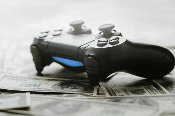 Concept of gaming addtion. Close up photo of gamepad on the money background. — Stock Photo, Image