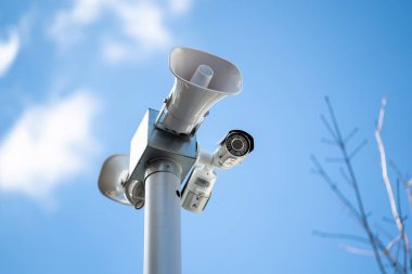 Güvenlik fotoğraf makinesi ile hoparlörler ve megafon gökyüzü arka plan üzerinde