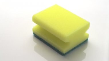 Beyaz arka planda yeşil jel şeklinde sarı dönen sünger ve dökme deterjan görüntüleri 4k süper makro yakın çekim