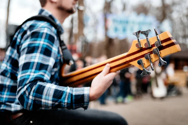 Фото музиканта, який грає на шести струнній бас-гітарі на вулиці перед людьми . — стокове фото