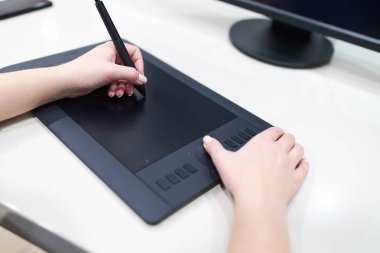 Bilgisayar grafik tablet üzerinde kalem ve boyama tutan, kadın illüstratör tasarımcının yakın çekim elleri. Serbest kavram.