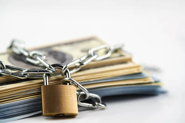 İş güvenliği veya finansal koruma veya kısıtlama erişimi. Beyaz üzerinde izole asma kilit ile zincir para yığını