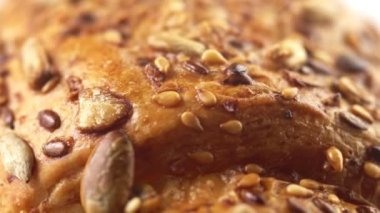 Ayçiçeği ve susam ile kaplı tatlı kruvasan veya çörek böreği dönen yüzey son derece makro 4k görüntüleri
